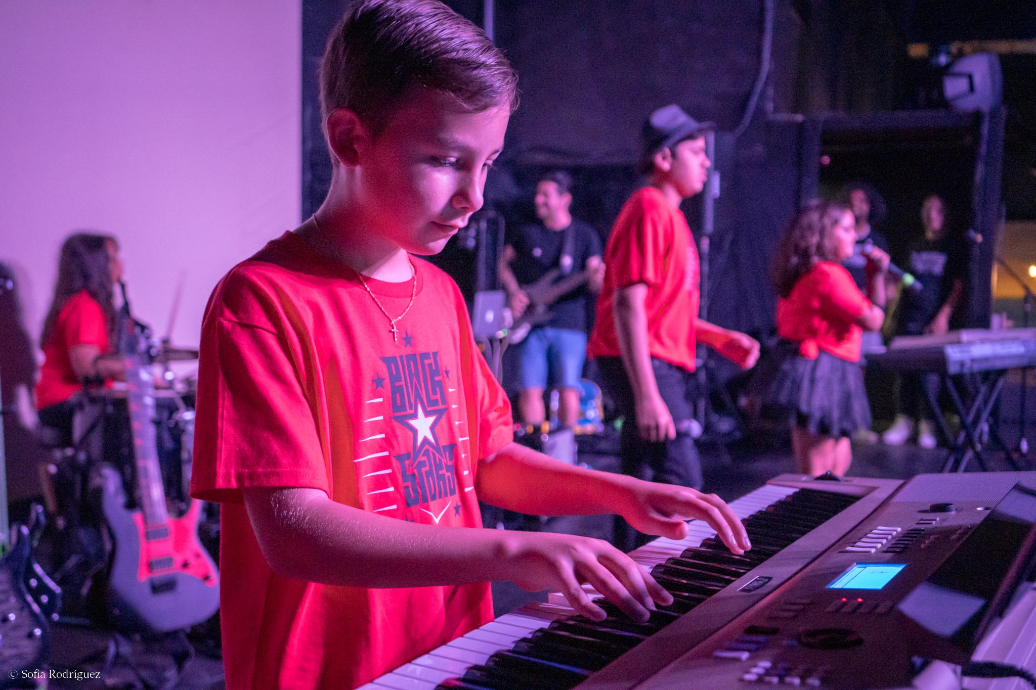 Boy playing keyboard during band program concert