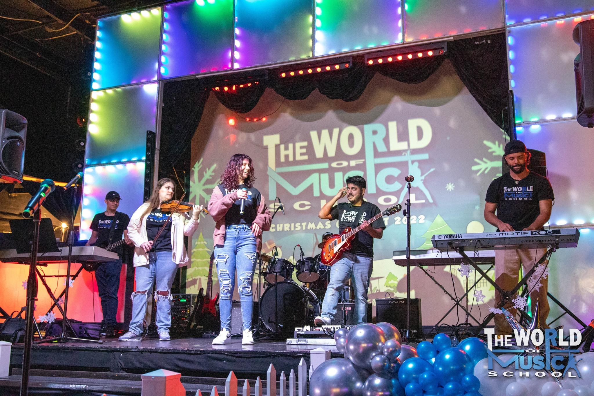 The World of Music School student band performing on stage at Christmas concert
