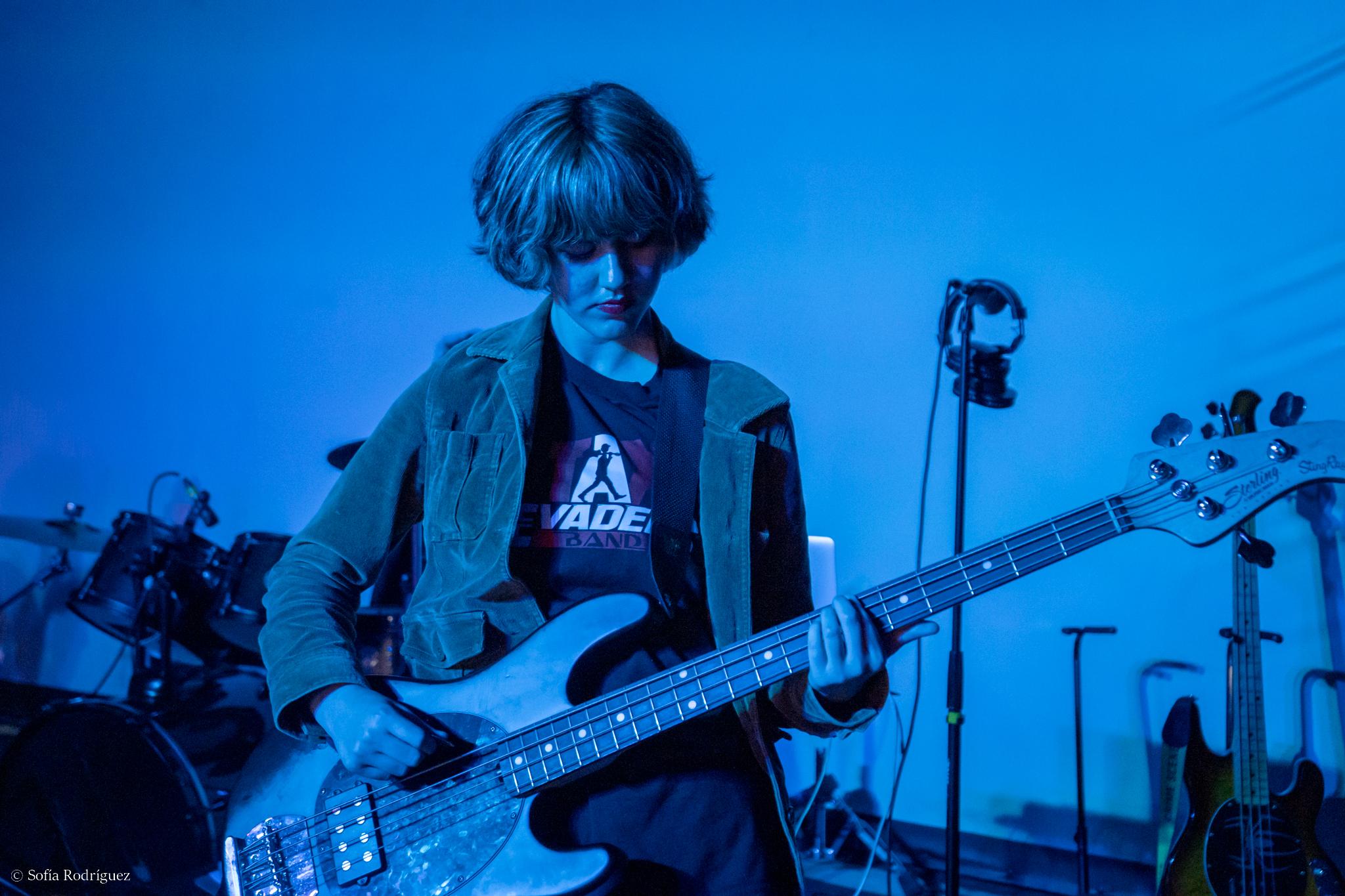 Bass guitar student performing with dramatic blue stage lighting