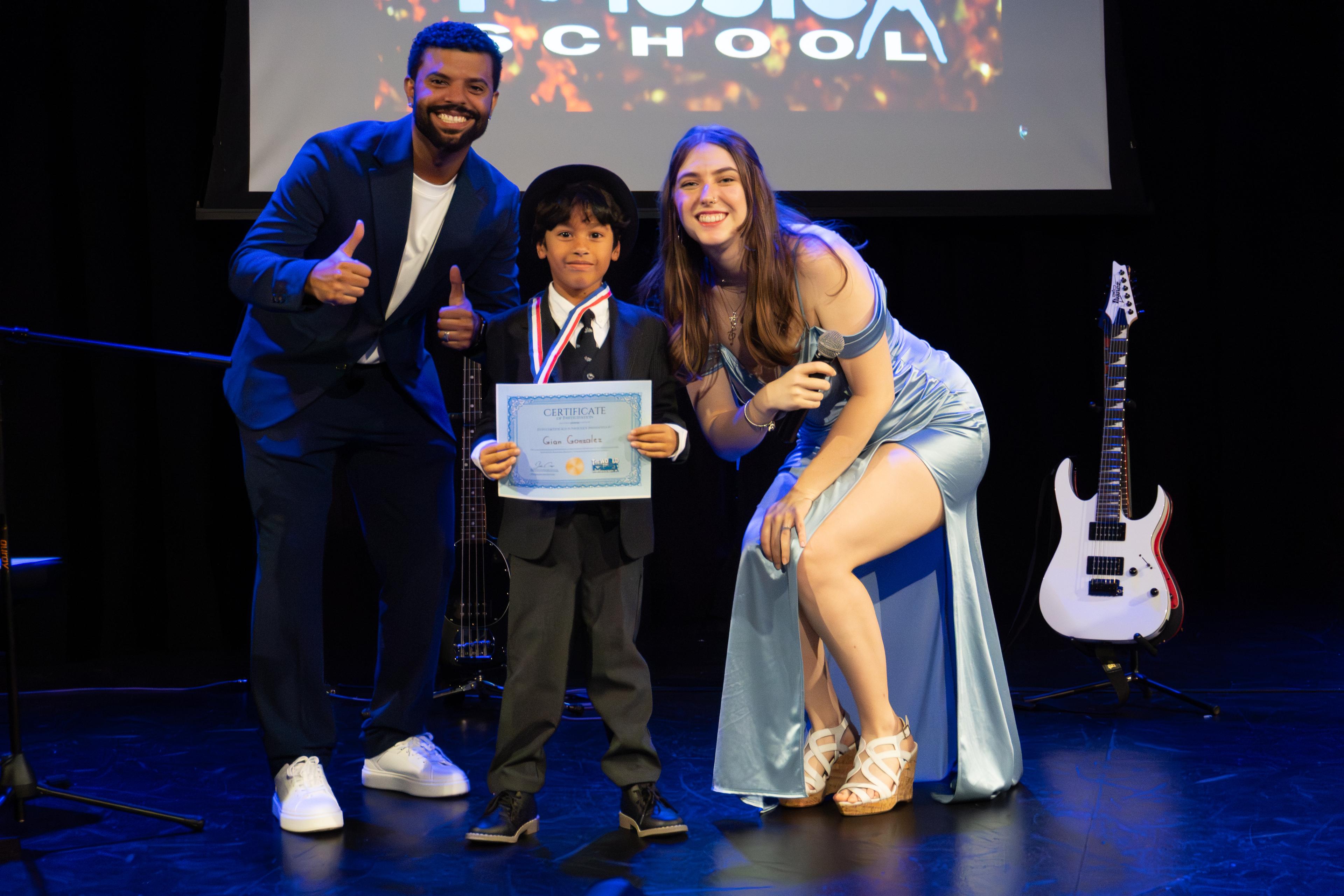 Young student receiving certificate and medal on stage at The World of Music School