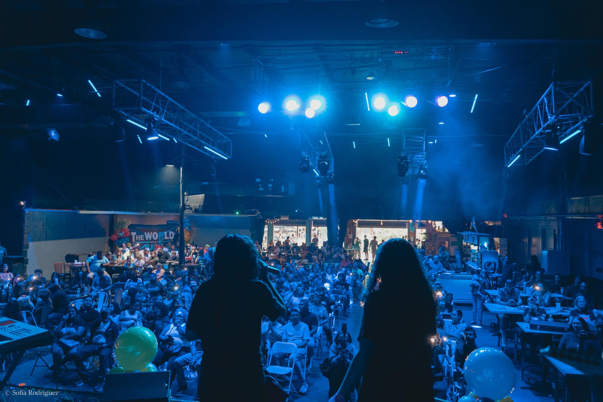Packed concert audience under blue lights