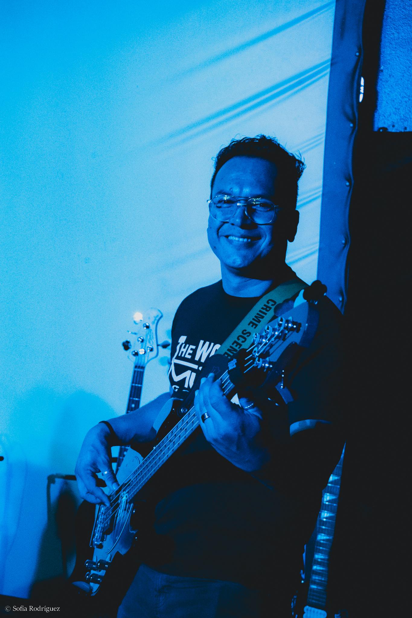 Teacher Charlie Ortiz playing bass on stage
