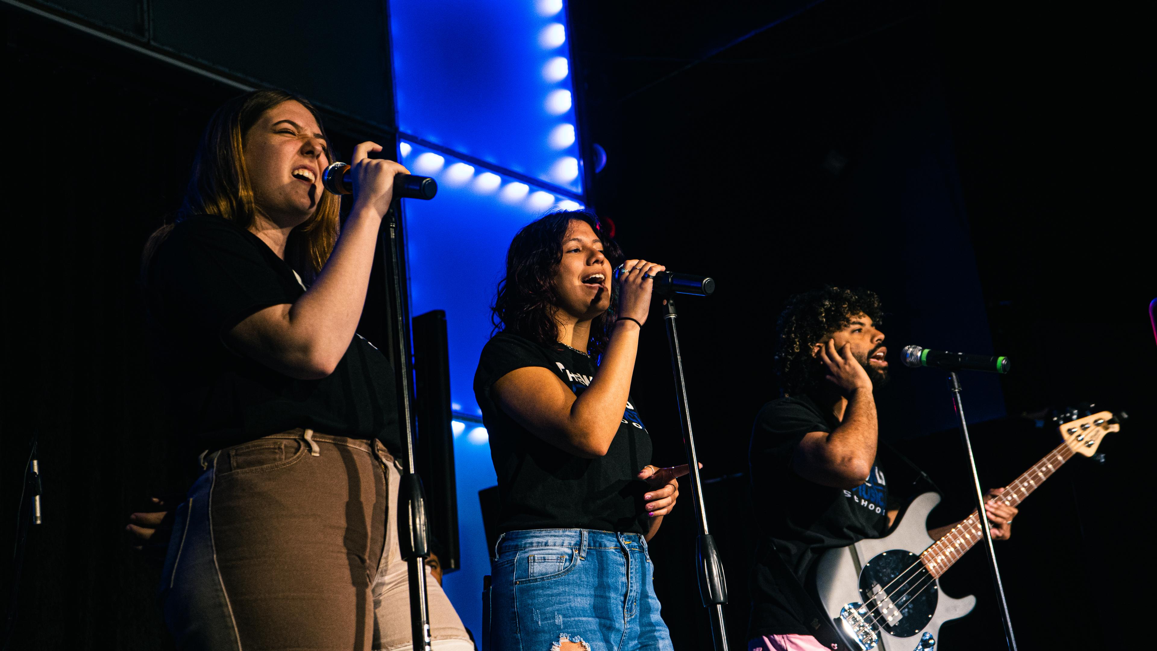 TWOM teachers performing on stage
