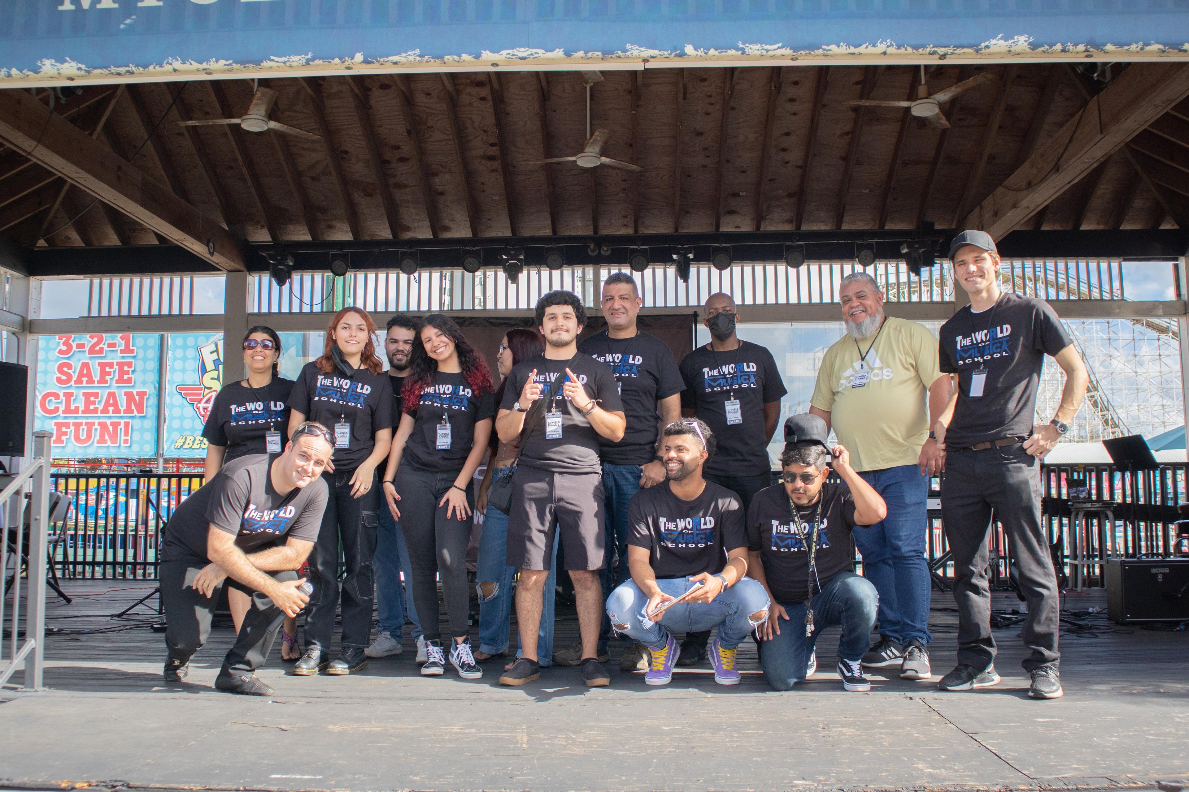 The full TWOM team on stage in matching shirts